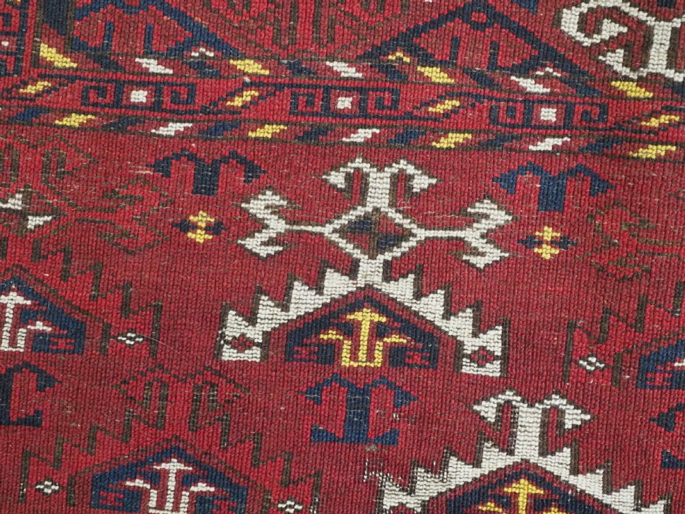 An antique hand-knotted Ersari Kizil Ayak Turkmen chuval face featuring nine octagonal guls on a deep red wool field with geometric borders. View XI