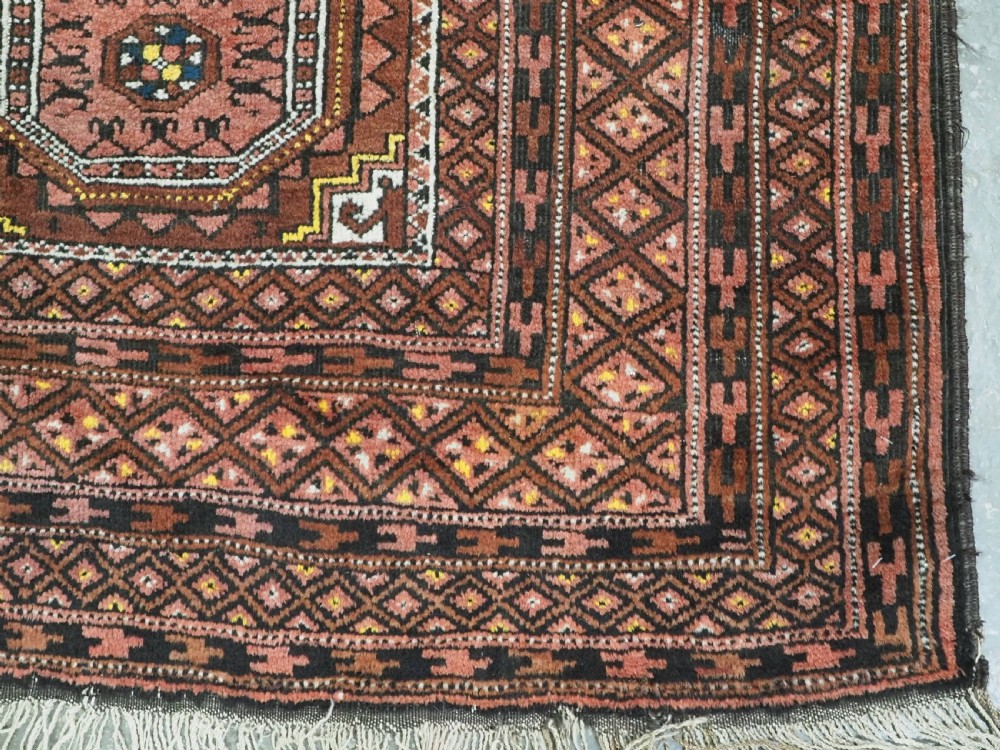 An antique hand-woven Salar Khani Baluch wool rug featuring geometric octagonal gul motifs in rust red, terracotta, and dark brown tones. View XII