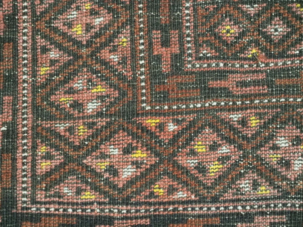 An antique hand-woven Salar Khani Baluch wool rug featuring geometric octagonal gul motifs in rust red, terracotta, and dark brown tones. View XIII