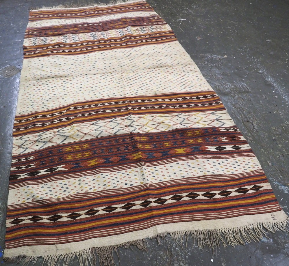 A flatwoven wool kilim rug featuring horizontal bands of cream, dark brown, and ochre with geometric diamond patterns. View II