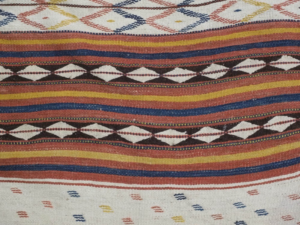 A flatwoven wool kilim rug featuring horizontal bands of cream, dark brown, and ochre with geometric diamond patterns. View VIII