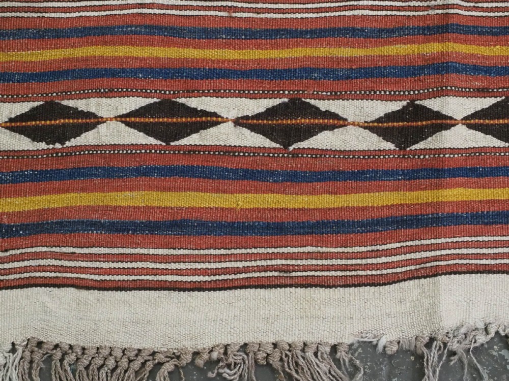 A flatwoven wool kilim rug featuring horizontal bands of cream, dark brown, and ochre with geometric diamond patterns. View XII