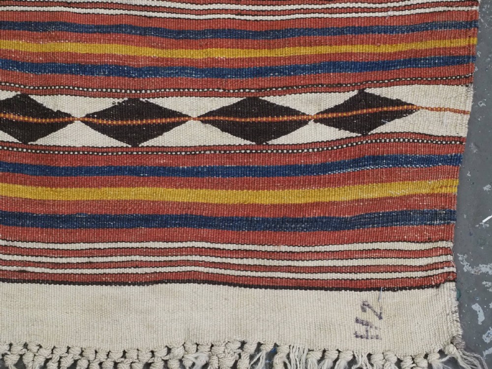 A flatwoven wool kilim rug featuring horizontal bands of cream, dark brown, and ochre with geometric diamond patterns. View XIII