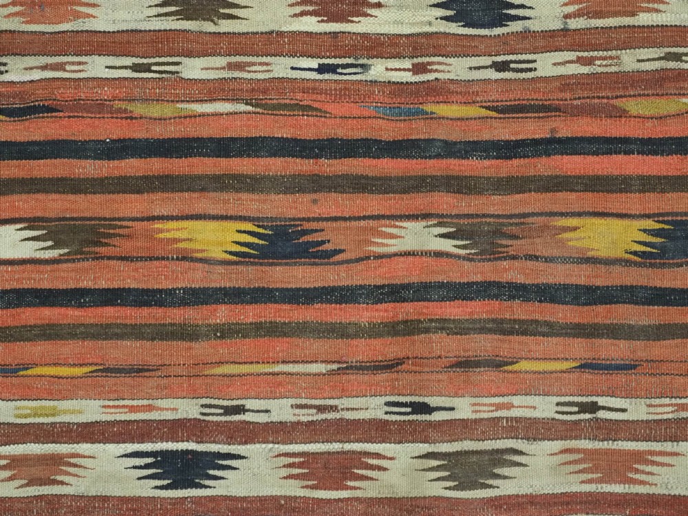 A long handwoven flatweave wool runner rug featuring horizontal bands of terracotta, dark brown, yellow, and cream geometric patterns. View IX