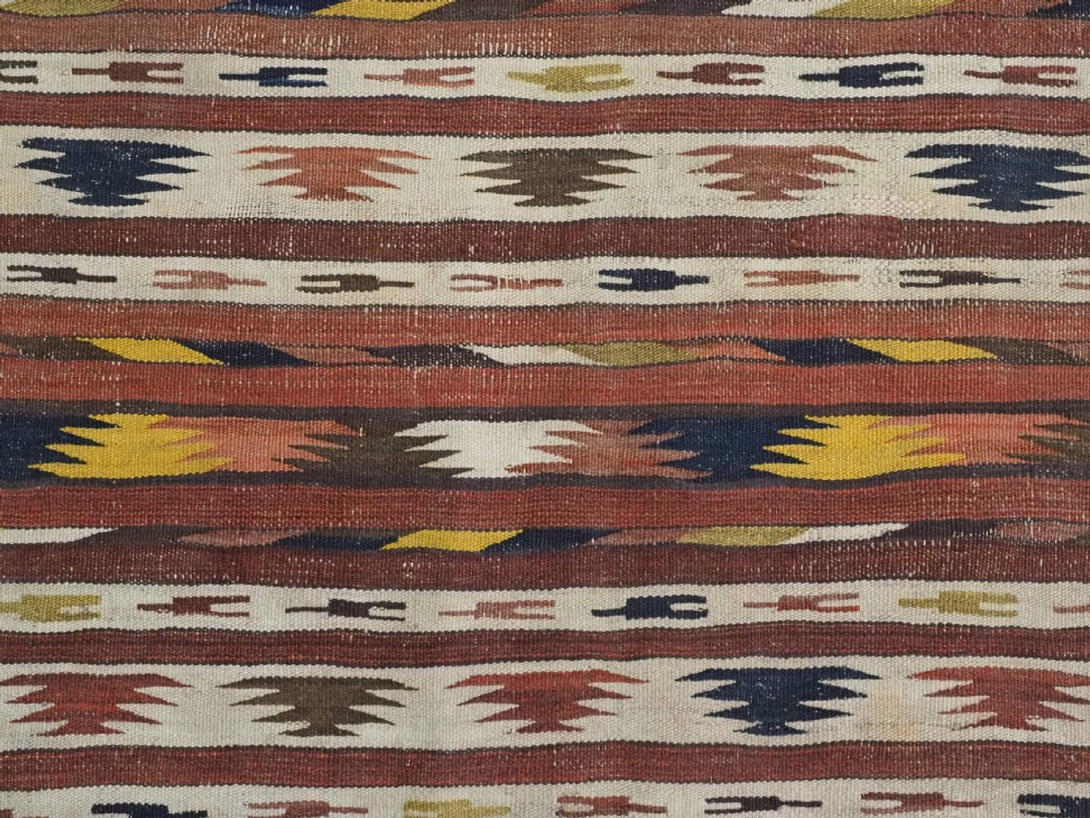 A long handwoven flatweave wool runner rug featuring horizontal bands of terracotta, dark brown, yellow, and cream geometric patterns. View XI