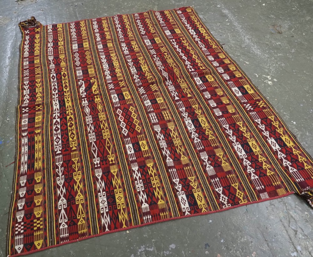 An antique handwoven Uzbek Gajeri wool kilim rug featuring vertical bands of geometric motifs in red, yellow, black, and cream shades. View II