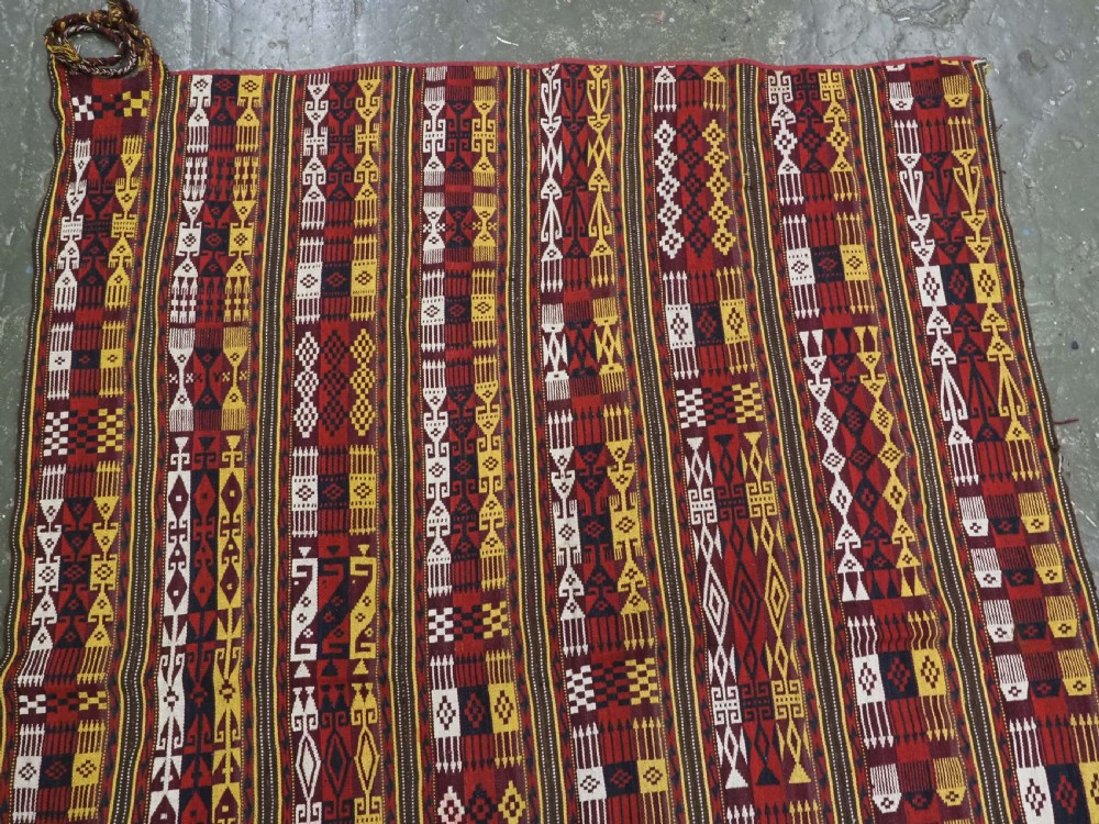 An antique handwoven Uzbek Gajeri wool kilim rug featuring vertical bands of geometric motifs in red, yellow, black, and cream shades. View III
