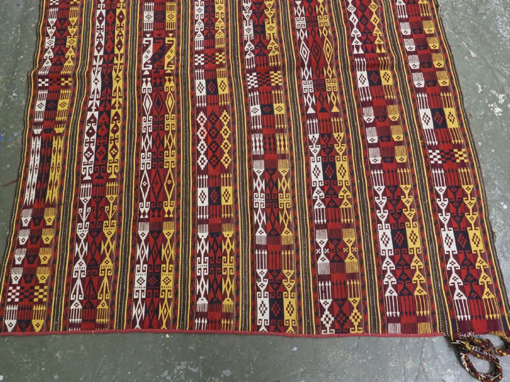 An antique handwoven Uzbek Gajeri wool kilim rug featuring vertical bands of geometric motifs in red, yellow, black, and cream shades. View IV