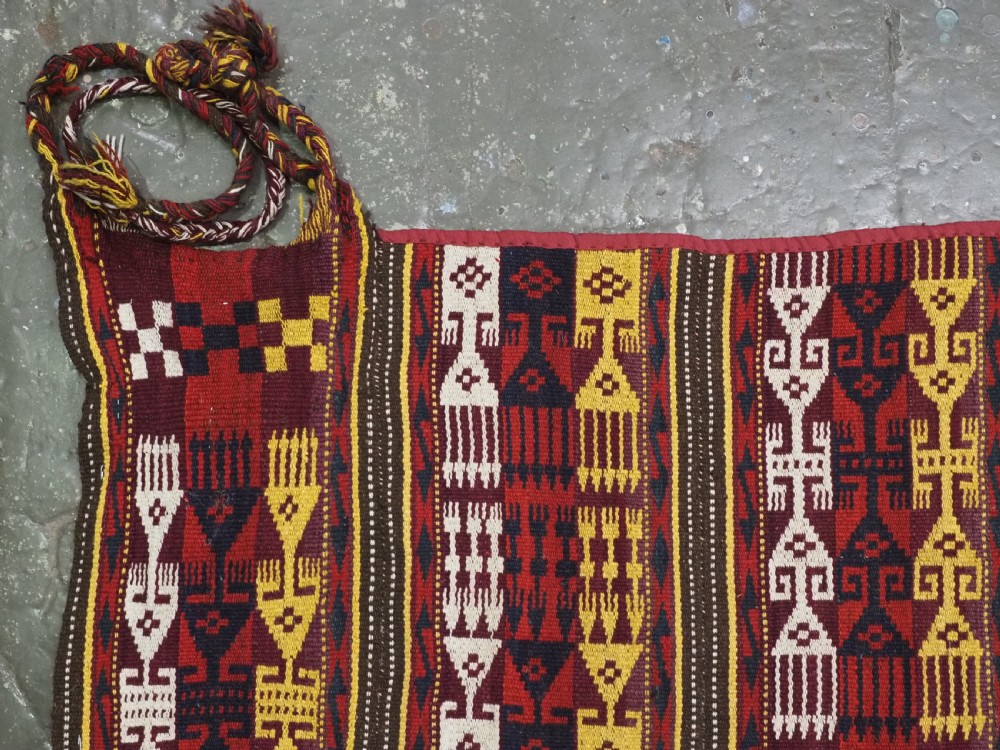 An antique handwoven Uzbek Gajeri wool kilim rug featuring vertical bands of geometric motifs in red, yellow, black, and cream shades. View V