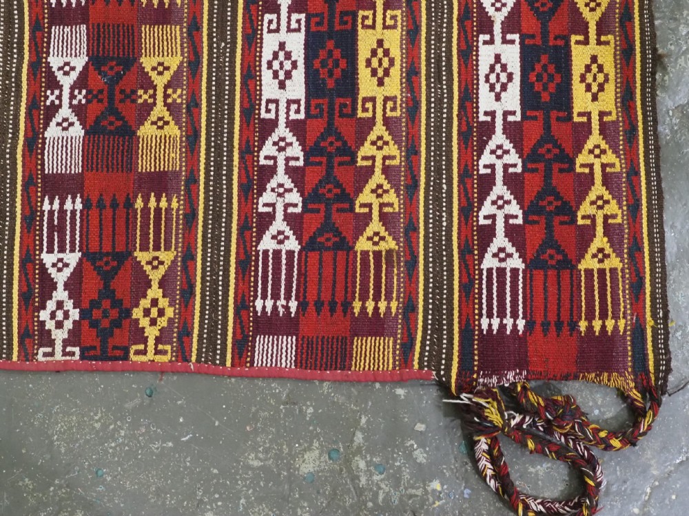 An antique handwoven Uzbek Gajeri wool kilim rug featuring vertical bands of geometric motifs in red, yellow, black, and cream shades. View IX
