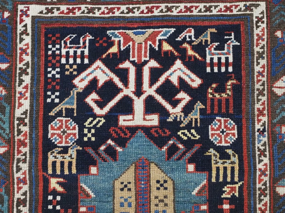 An antique late nineteenth-century Caucasian Kuba runner featuring geometric medallions and stylised animal motifs in navy blue, red, and cream wool. View VIII