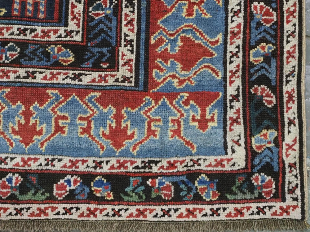 An antique late nineteenth-century Caucasian Kuba runner featuring geometric medallions and stylised animal motifs in navy blue, red, and cream wool. View XIII