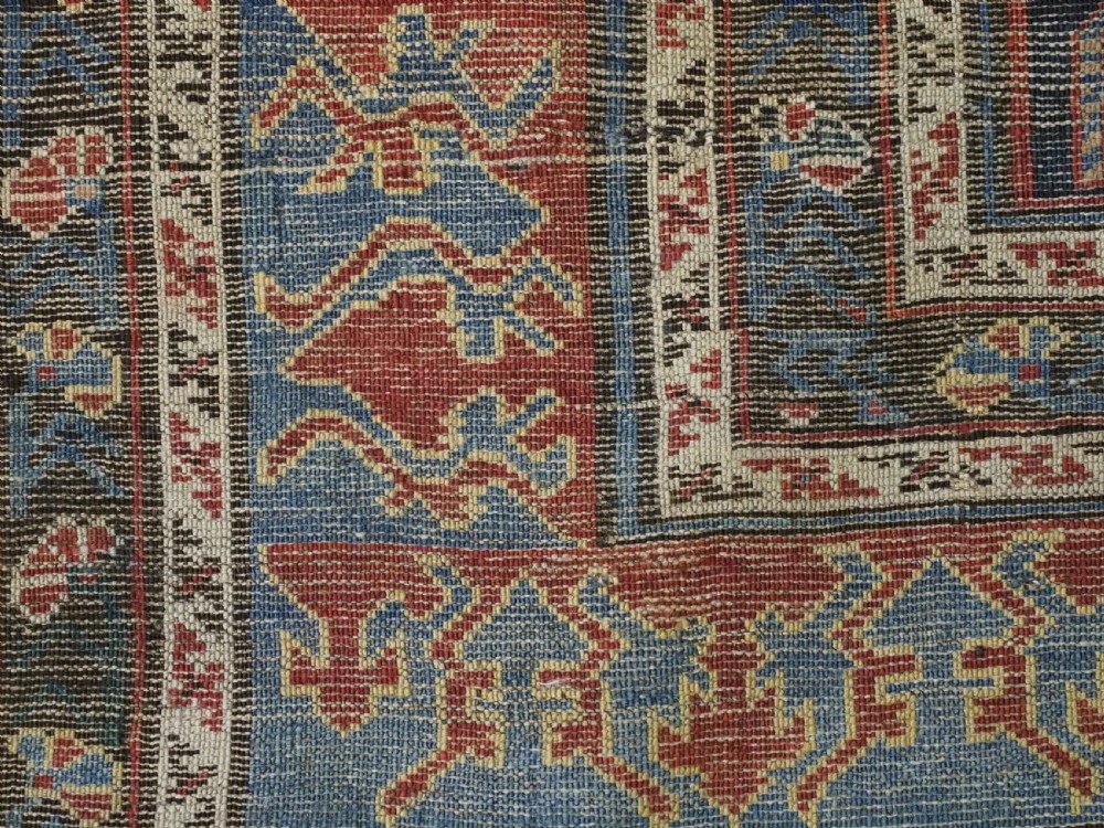 An antique late nineteenth-century Caucasian Kuba runner featuring geometric medallions and stylised animal motifs in navy blue, red, and cream wool. View XIV