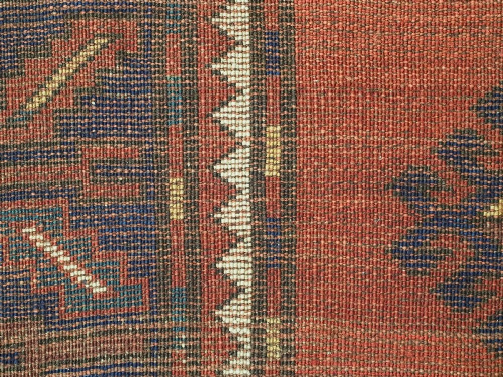 An antique Caucasian Kazak hand-knotted wool rug featuring three large geometric medallions along a rich red field surrounded by a dark blue border. View XIV