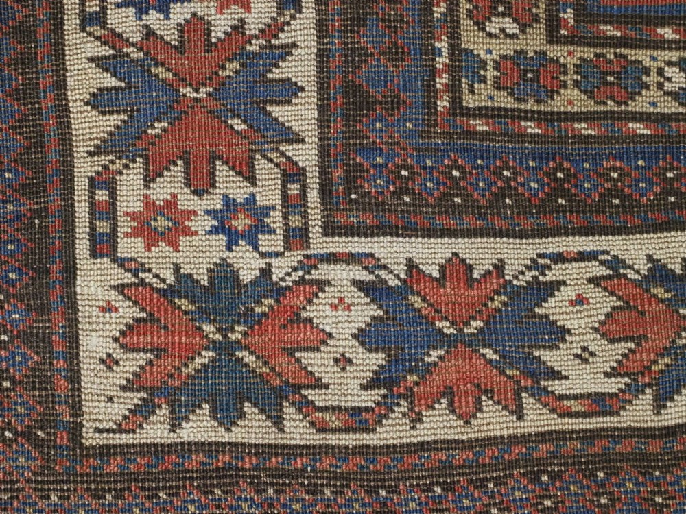 An antique hand-knotted Caucasian Moghan Kazak wool runner featuring four central hooked diamond medallions on a red field enclosed by multi-band geometric borders. View XIII