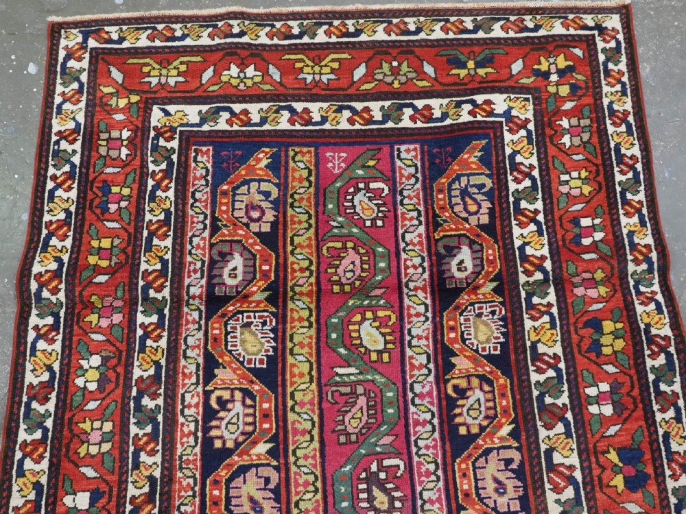 An antique Caucasian Karabagh runner rug featuring vertical polychrome stripes filled with repeating boteh motifs framed by multiple floral borders. View II