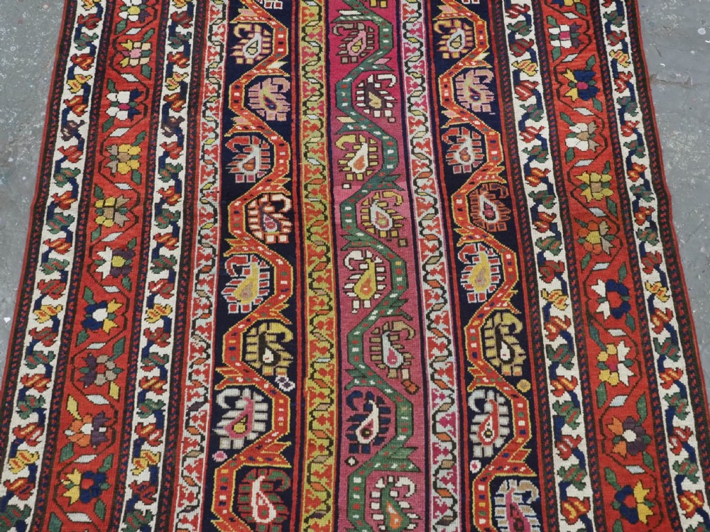 An antique Caucasian Karabagh runner rug featuring vertical polychrome stripes filled with repeating boteh motifs framed by multiple floral borders. View III