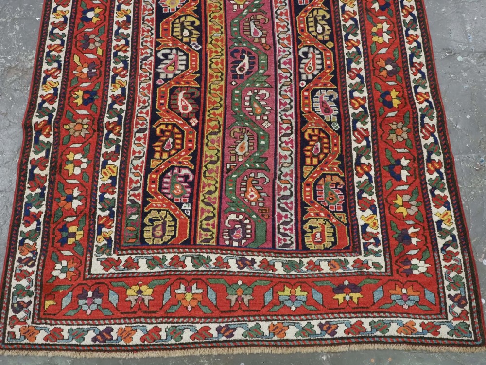 An antique Caucasian Karabagh runner rug featuring vertical polychrome stripes filled with repeating boteh motifs framed by multiple floral borders. View IV