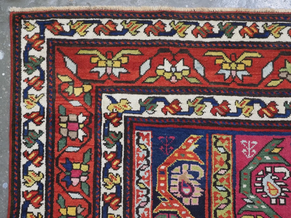 An antique Caucasian Karabagh runner rug featuring vertical polychrome stripes filled with repeating boteh motifs framed by multiple floral borders. View V