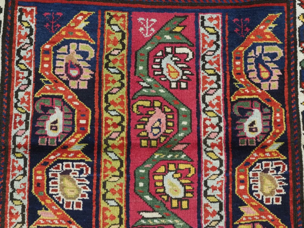 An antique Caucasian Karabagh runner rug featuring vertical polychrome stripes filled with repeating boteh motifs framed by multiple floral borders. View VII