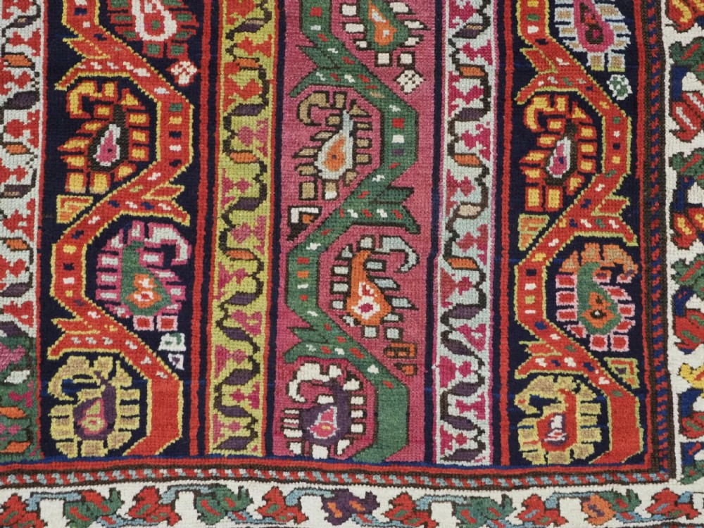 An antique Caucasian Karabagh runner rug featuring vertical polychrome stripes filled with repeating boteh motifs framed by multiple floral borders. View IX