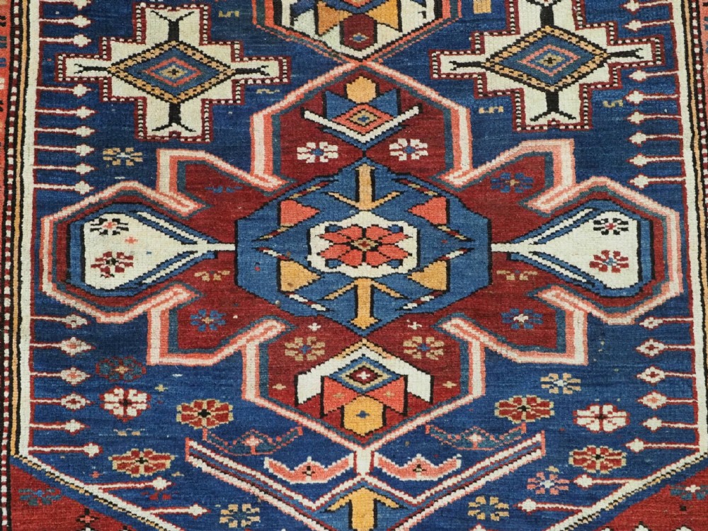 A hand-knotted antique Caucasian rug featuring three lobed medallions on a navy blue field surrounded by intricate geometric borders. View XI