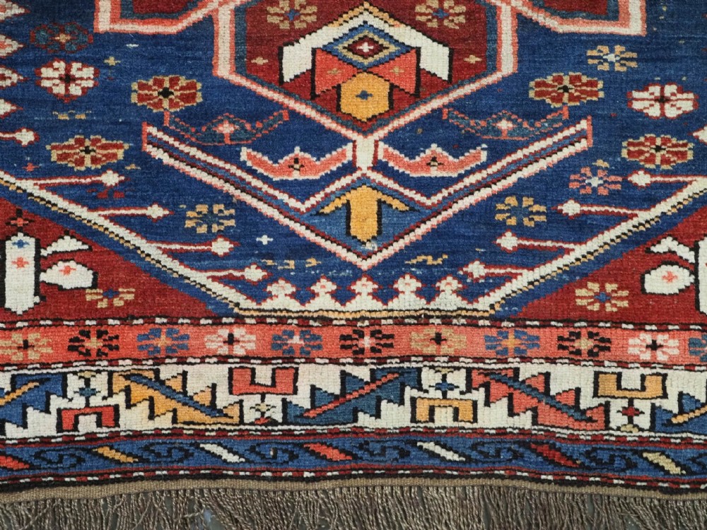 A hand-knotted antique Caucasian rug featuring three lobed medallions on a navy blue field surrounded by intricate geometric borders. View XII