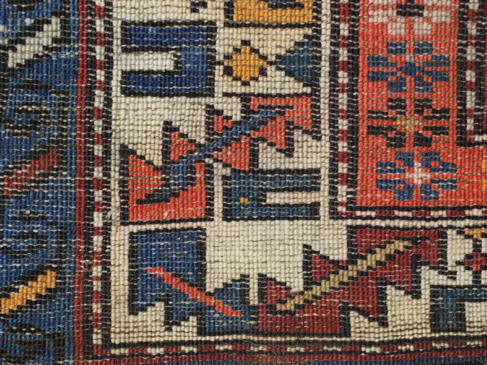 A hand-knotted antique Caucasian rug featuring three lobed medallions on a navy blue field surrounded by intricate geometric borders. View XIV