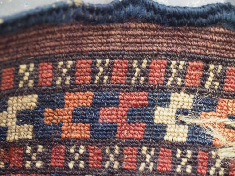 A narrow hand-knotted wool Turkmen spindle bag featuring chevron geometric patterns in terracotta, yellow, and dark brown with long side and bottom tassels. View VI