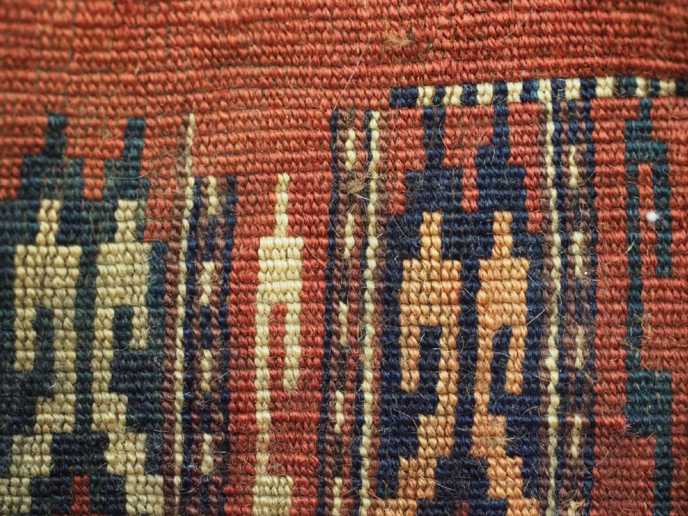 A narrow hand-knotted wool Yomut Turkmen spindle bag with rust red geometric vertical patterns, multi-coloured tassels along the edges, and a braided hanging loop. View VI