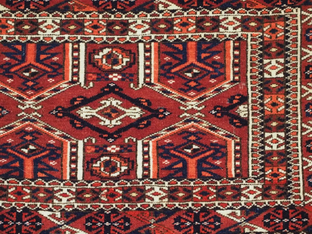 Horizontal handwoven Turkmen wool torba bag featuring deep red and indigo geometric kedjebe motifs with long woollen fringe along the bottom edge. View VIII