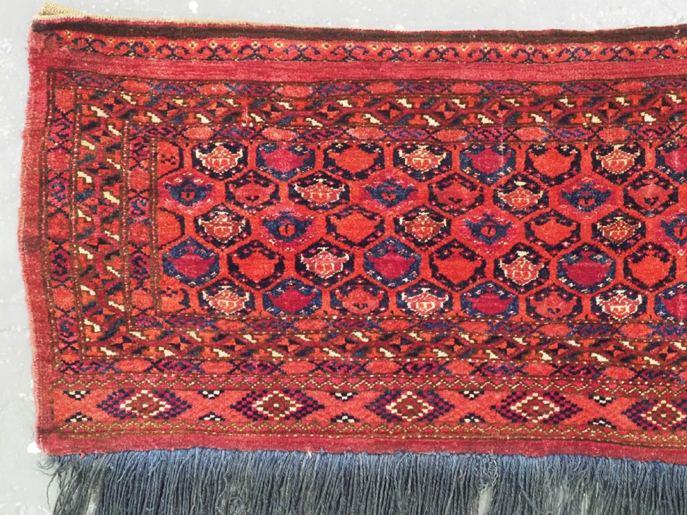 A horizontal rectangular hand-knotted Turkmen torba with repeating red and blue Shemle guls and long wool fringe along the lower border. View II