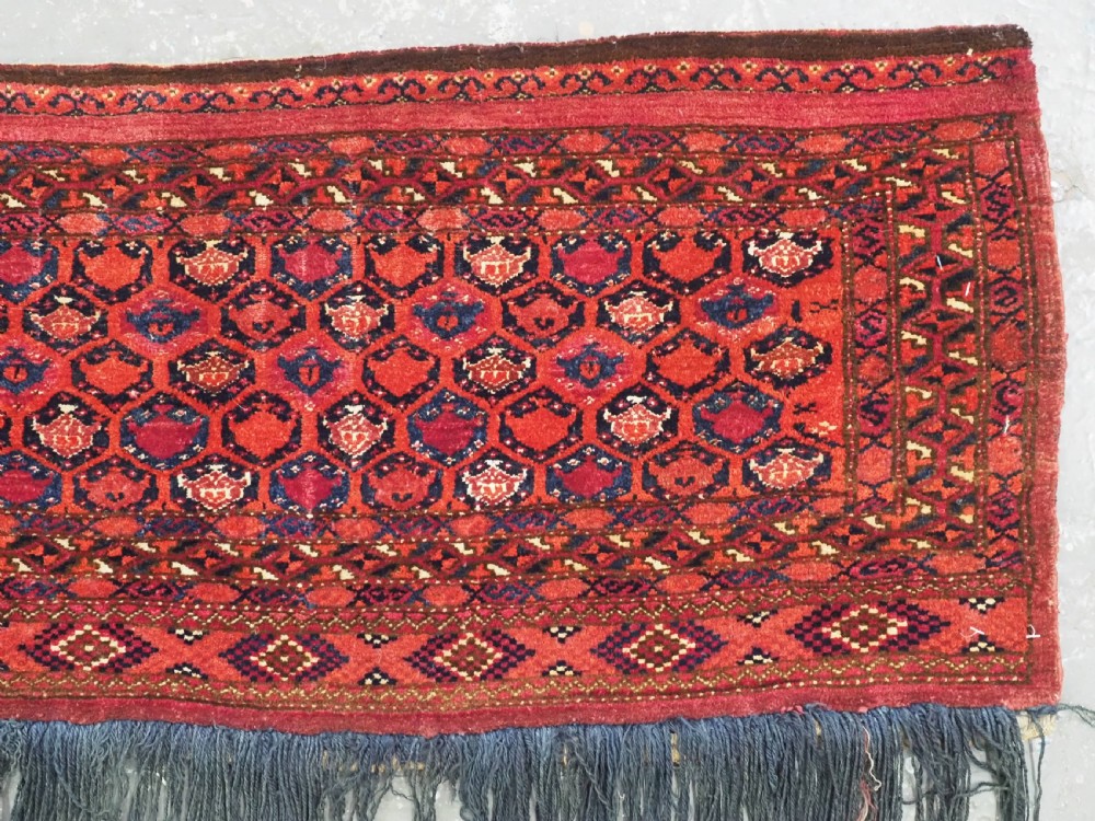 A horizontal rectangular hand-knotted Turkmen torba with repeating red and blue Shemle guls and long wool fringe along the lower border. View III