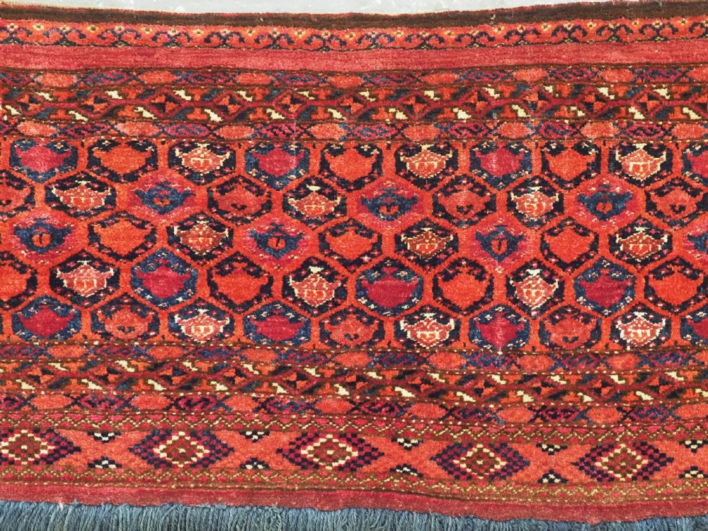 A horizontal rectangular hand-knotted Turkmen torba with repeating red and blue Shemle guls and long wool fringe along the lower border. View IV