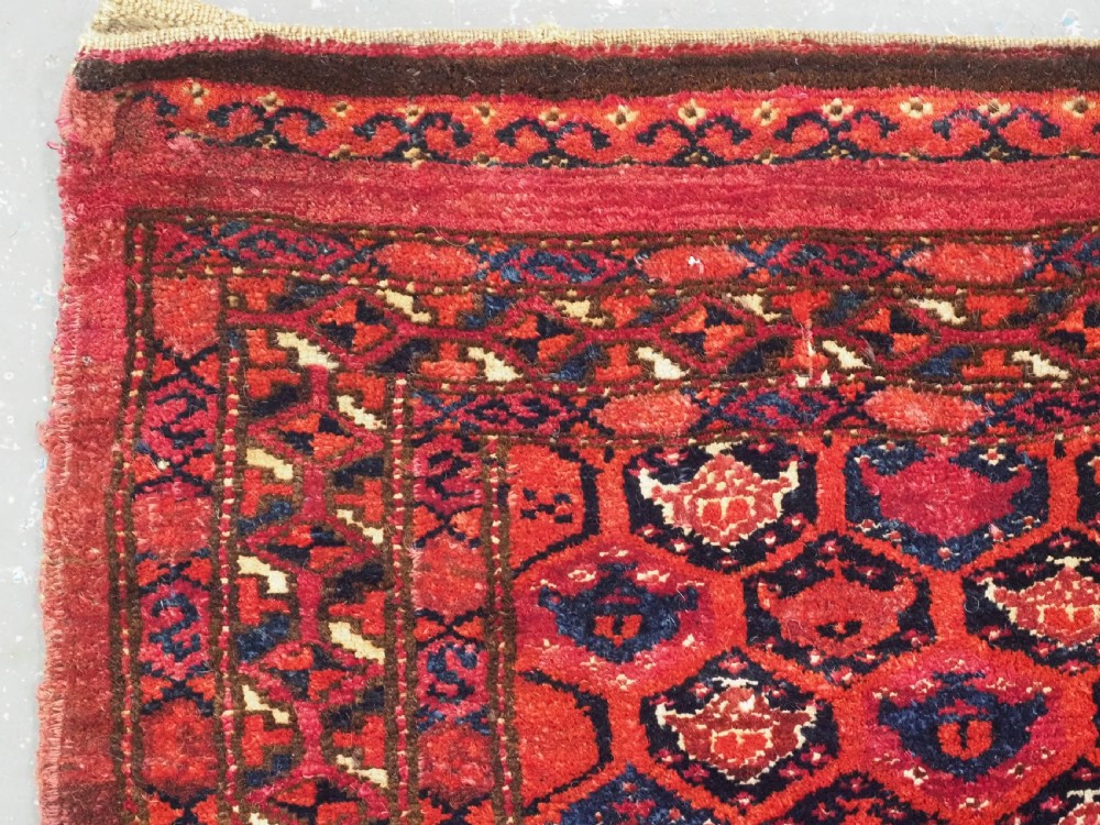 A horizontal rectangular hand-knotted Turkmen torba with repeating red and blue Shemle guls and long wool fringe along the lower border. View V