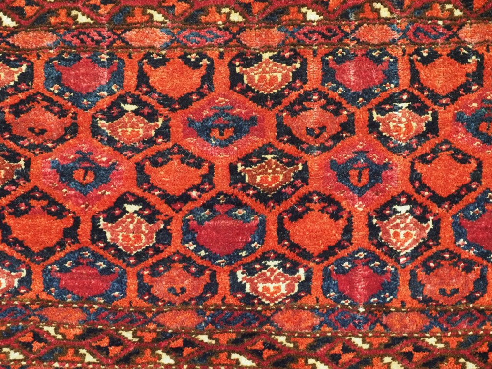 A horizontal rectangular hand-knotted Turkmen torba with repeating red and blue Shemle guls and long wool fringe along the lower border. View VII