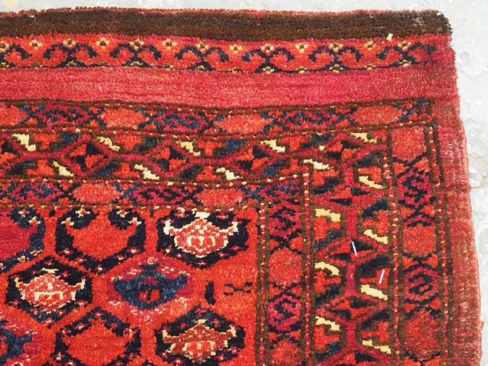 A horizontal rectangular hand-knotted Turkmen torba with repeating red and blue Shemle guls and long wool fringe along the lower border. View VIII