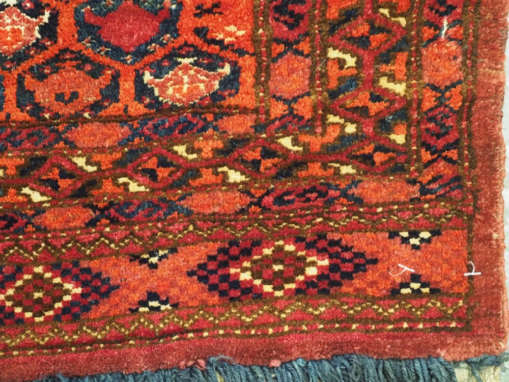 A horizontal rectangular hand-knotted Turkmen torba with repeating red and blue Shemle guls and long wool fringe along the lower border. View IX