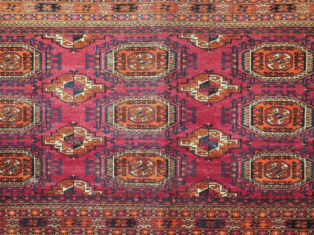 A rectangular hand-knotted crimson red Turkmen chuval featuring nine central octagonal Salor guls framed by ornate geometric borders and a decorative lower elem panel. View VI