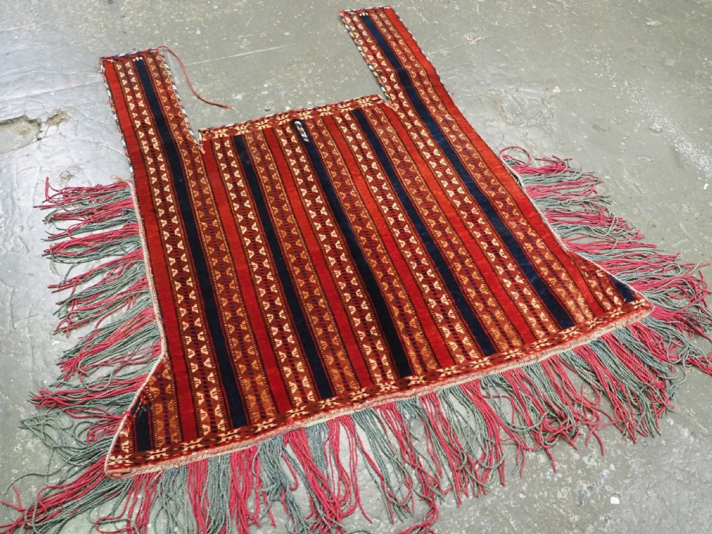 An antique Yomut Turkmen handwoven wool horse cover with vertical geometric stripes in dark blue, ivory, and terracotta red, edged with fringe trim. View II
