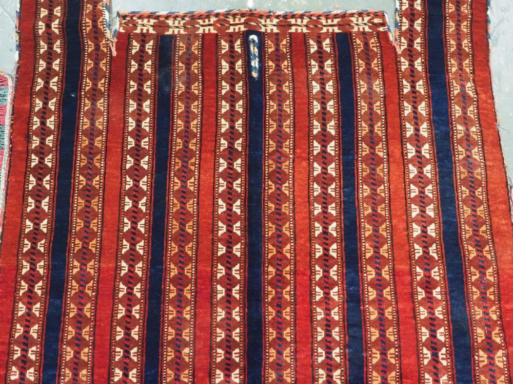 An antique Yomut Turkmen handwoven wool horse cover with vertical geometric stripes in dark blue, ivory, and terracotta red, edged with fringe trim. View IV