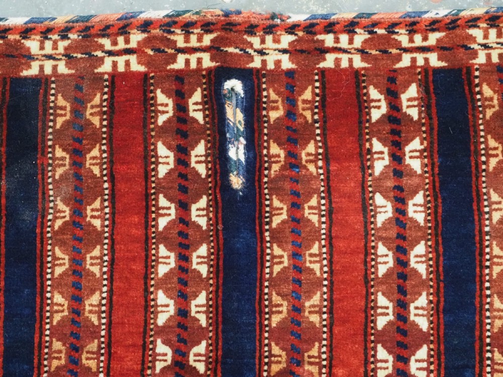 An antique Yomut Turkmen handwoven wool horse cover with vertical geometric stripes in dark blue, ivory, and terracotta red, edged with fringe trim. View VI