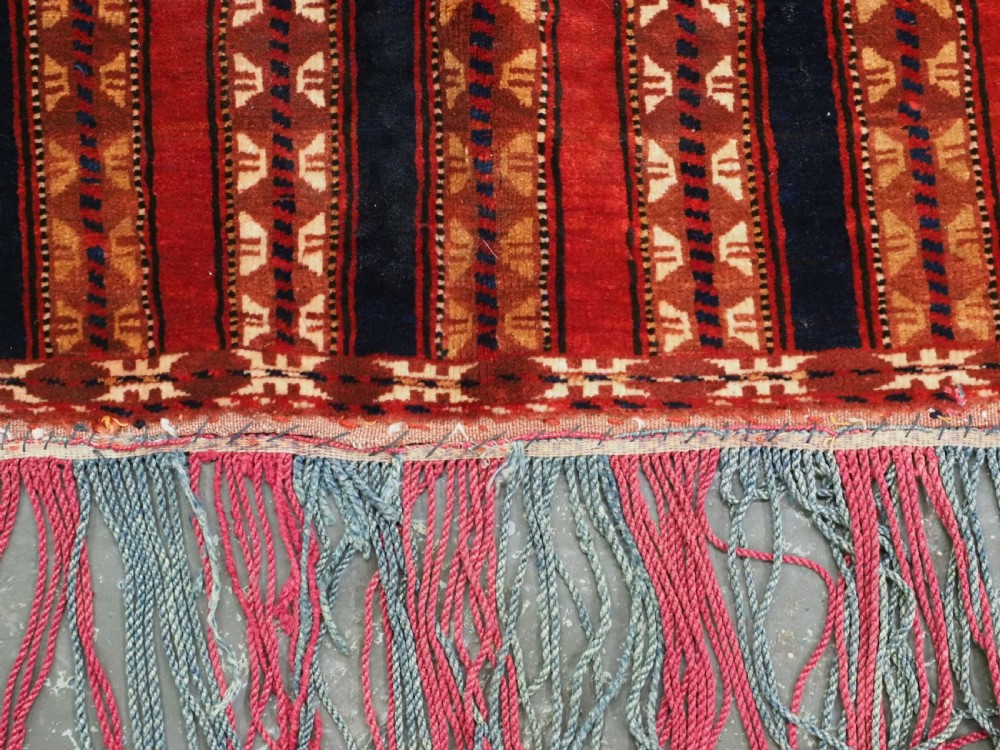 An antique Yomut Turkmen handwoven wool horse cover with vertical geometric stripes in dark blue, ivory, and terracotta red, edged with fringe trim. View IX
