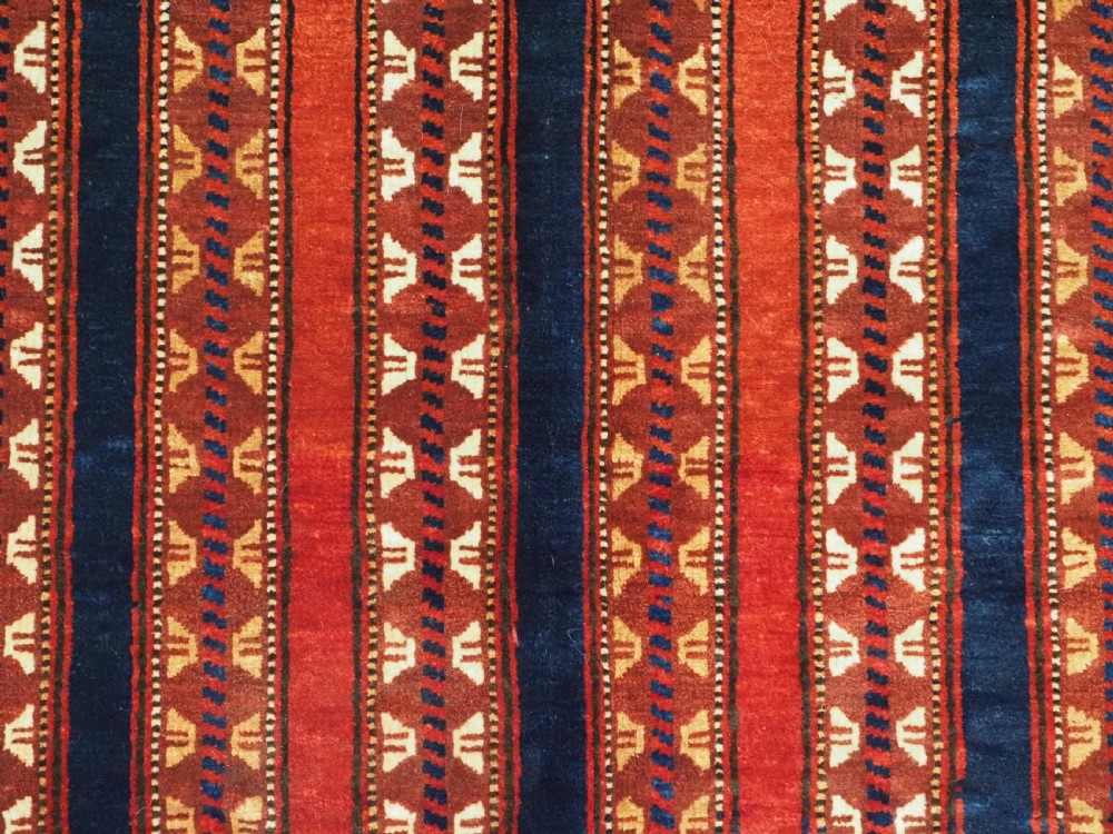 An antique Yomut Turkmen handwoven wool horse cover with vertical geometric stripes in dark blue, ivory, and terracotta red, edged with fringe trim. View XI