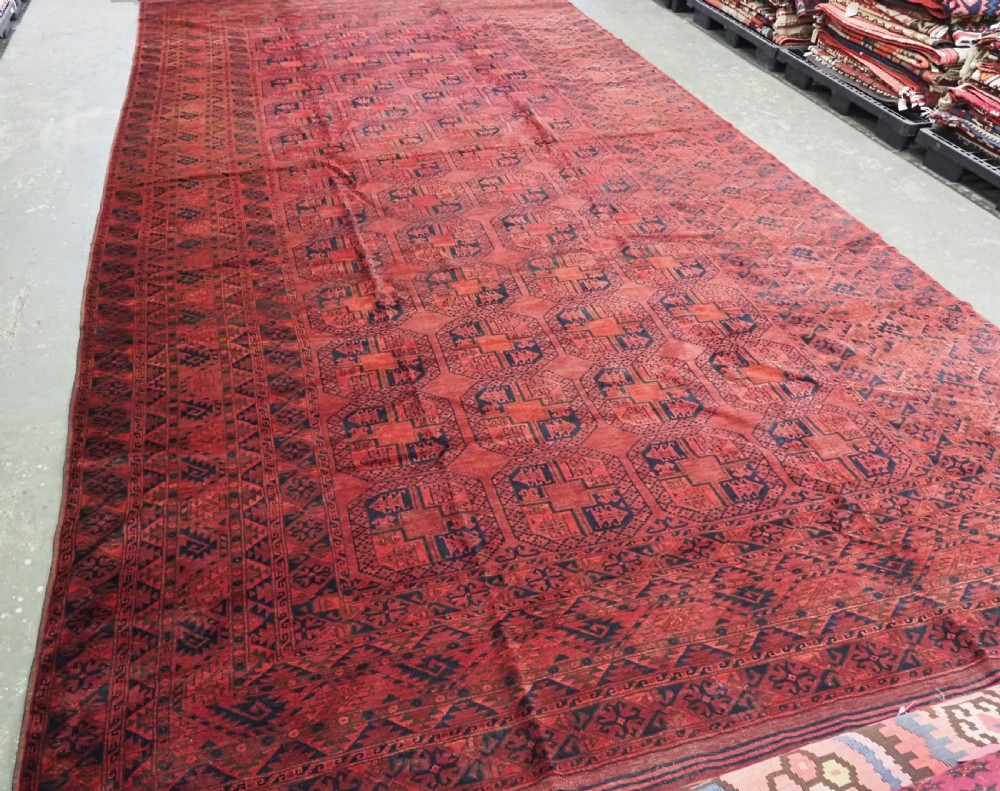 A large antique Afghan Ersari hand-knotted wool carpet featuring repeating octagonal gul motifs across a deep red field framed by geometric borders. View II