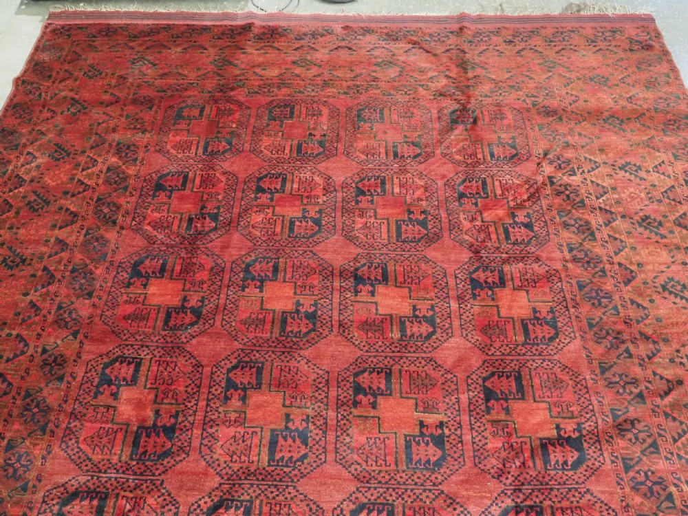 A large antique Afghan Ersari hand-knotted wool carpet featuring repeating octagonal gul motifs across a deep red field framed by geometric borders. View III