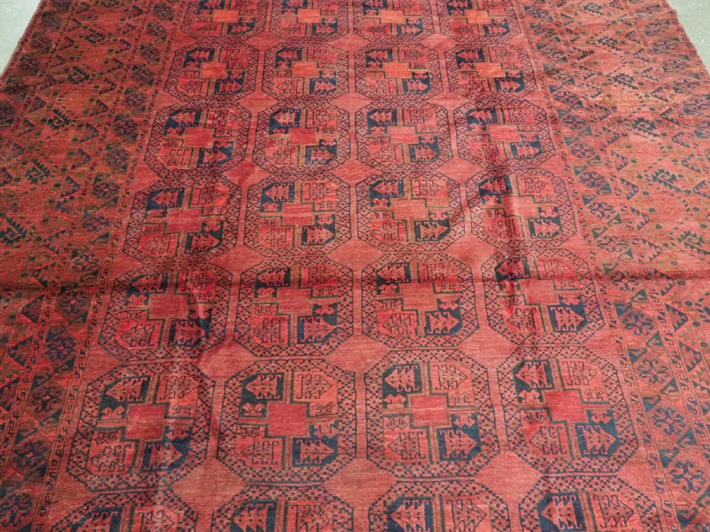 A large antique Afghan Ersari hand-knotted wool carpet featuring repeating octagonal gul motifs across a deep red field framed by geometric borders. View IV