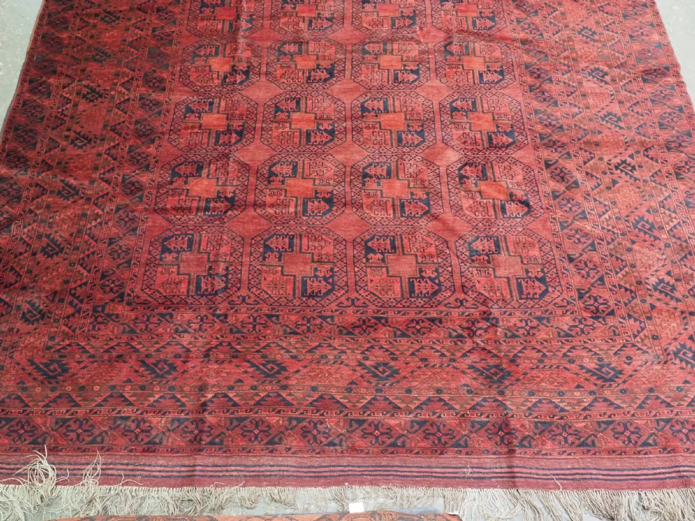 A large antique Afghan Ersari hand-knotted wool carpet featuring repeating octagonal gul motifs across a deep red field framed by geometric borders. View VI