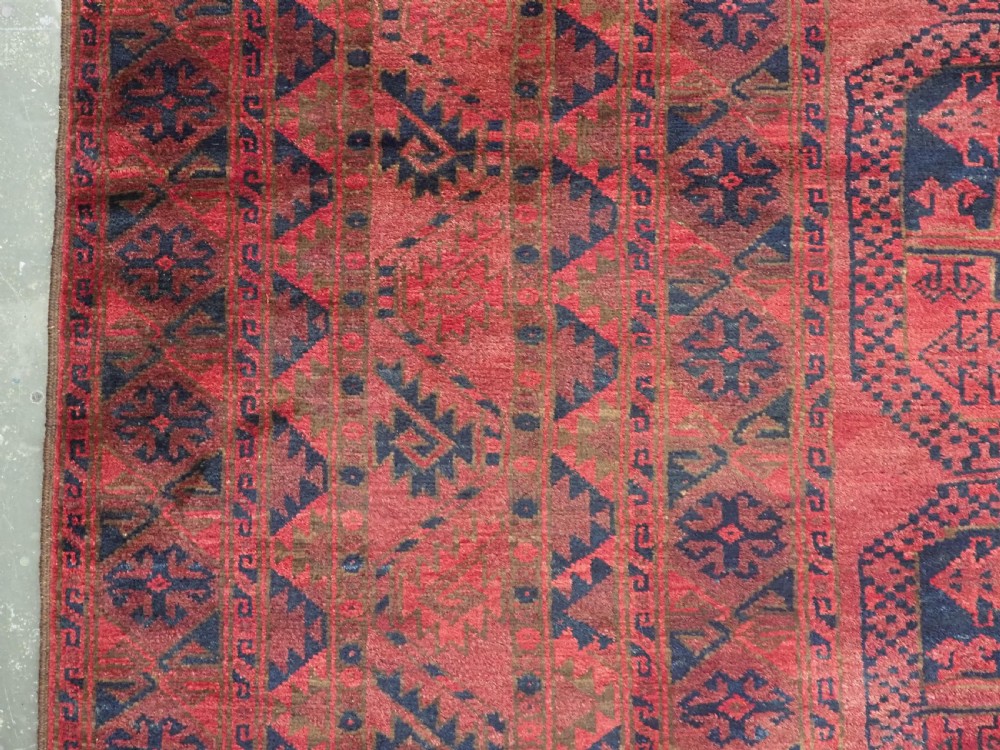 A large antique Afghan Ersari hand-knotted wool carpet featuring repeating octagonal gul motifs across a deep red field framed by geometric borders. View VIII
