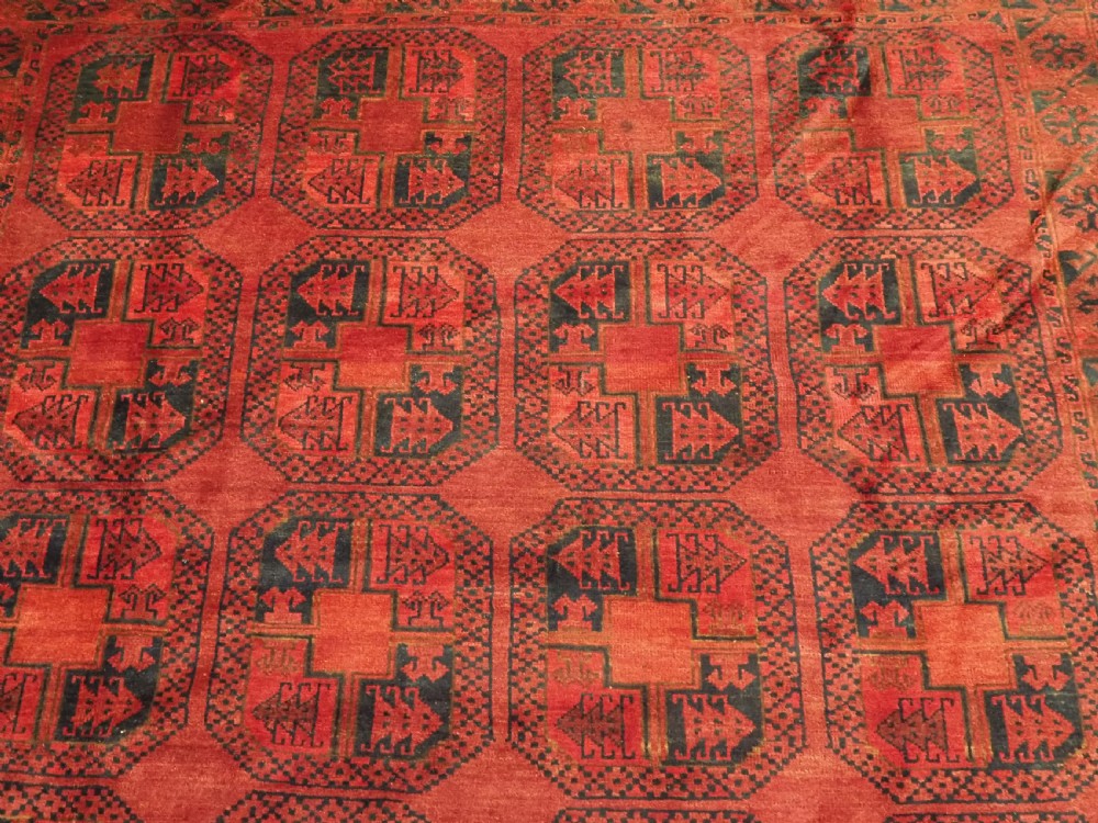 A large antique Afghan Ersari hand-knotted wool carpet featuring repeating octagonal gul motifs across a deep red field framed by geometric borders. View IX